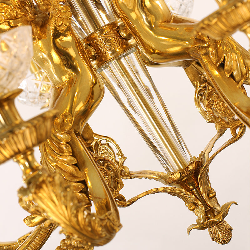 Detailed view of cherub sculpture on antique chandelier in golden brass.