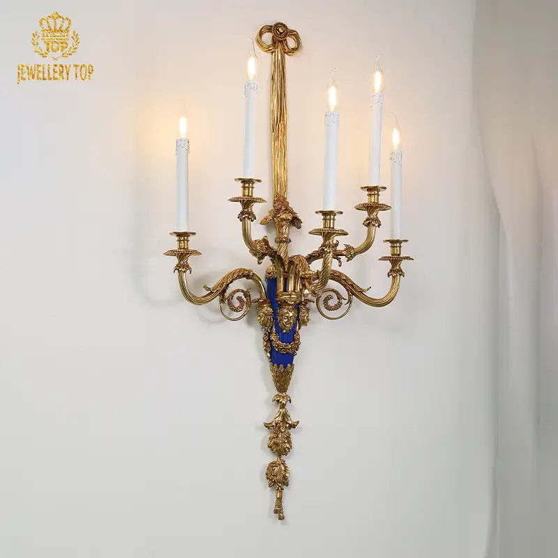 Five-arm vintage sconce illuminating white textured wall