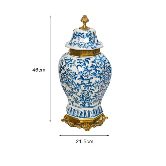 Full front view of a decorative ceramic jar with a brass finial lid and blue botanical motifs.