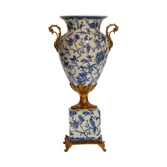 Front perspective of a blue and white porcelain vase with bird and floral motifs, and brass side handles.