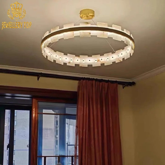 Close-up of veined alabaster panels and sunburst brass detailing on ceiling fixture