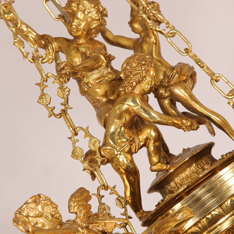 Close-up of beautifully crafted brass cherubs adding a vintage charm to the chandelier.