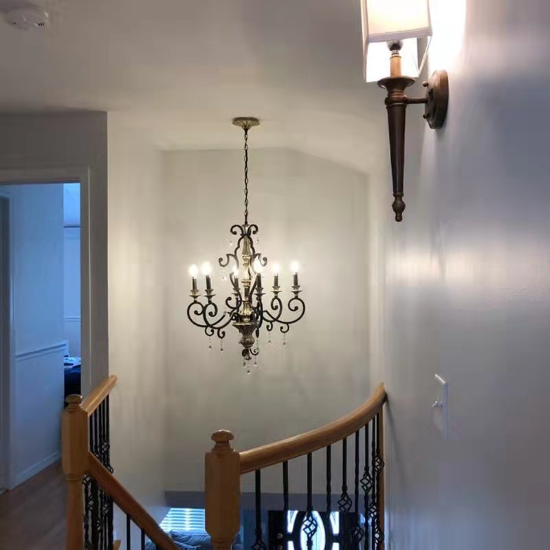 Vintage chandelier casting warm amber glow over a ceramic floral centerpiece