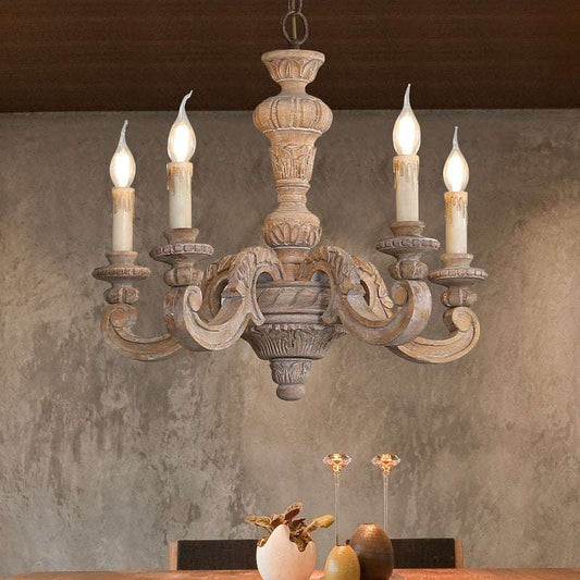 Close-up of distressed barn wood and wrought-iron floral carvings on country lighting