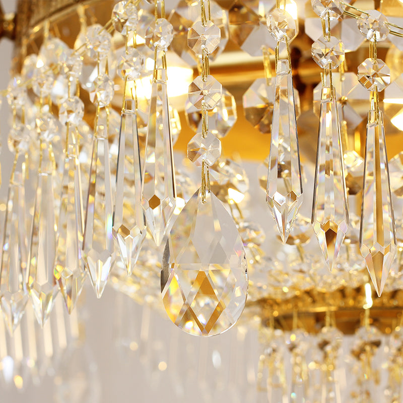 Close-up view of sparkling crystal pendants reflecting light in a brass ceiling lamp.