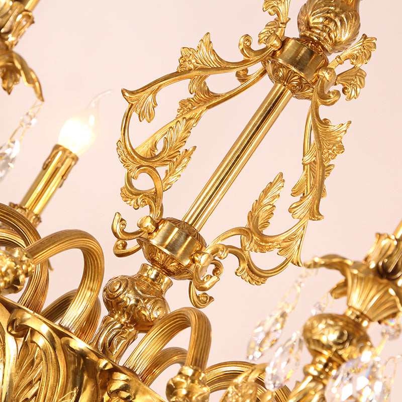 Close-up of intricate brass scrollwork on the chandelier's upper crown.