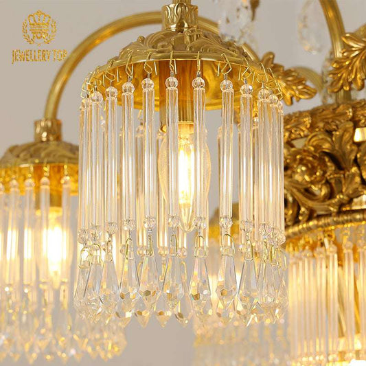 Close-up of crystal prisms reflecting warm light in a brass chandelier.
