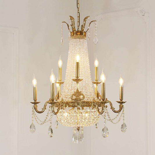 Close-up of gleaming brass framework supporting multiple candle-style lights.