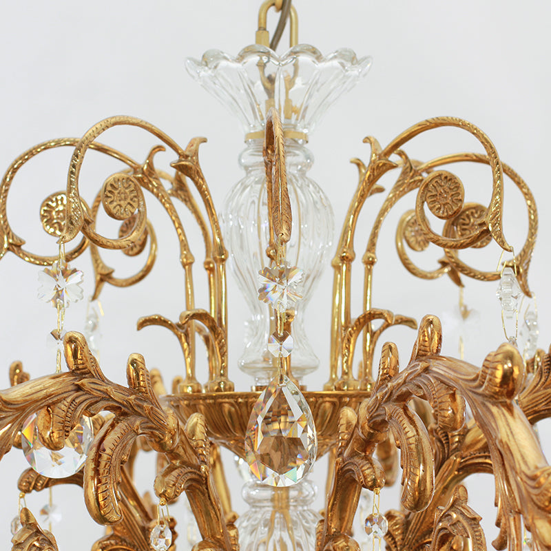 Close-up detail showing the brass arms and crystal glass lampshades of the vintage chandelier.