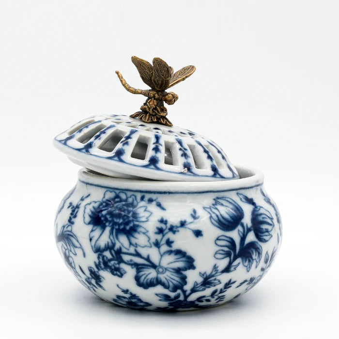 Ceramic aroma stove with blue floral patterns and brass butterfly atop white lid