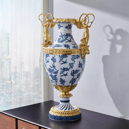 Decorative vase with blue and white floral and bird patterns, featuring brass angel handle