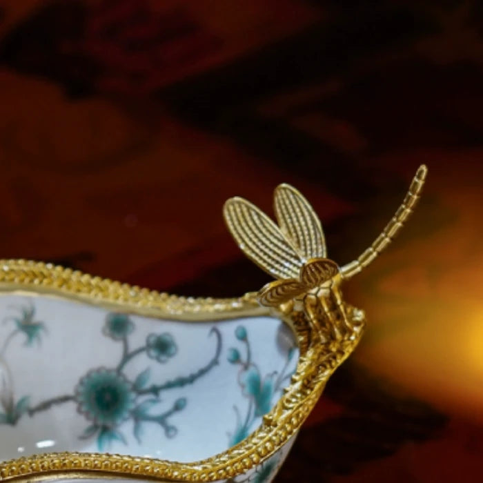 Full view of decorative dish with brass dragonfly accent and scrolled legs