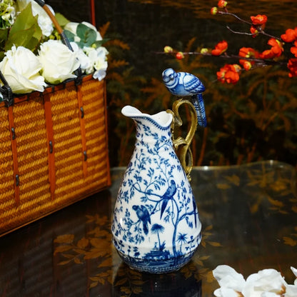 Decorative vase featuring brass handle with ceramic bird accent and floral patterns