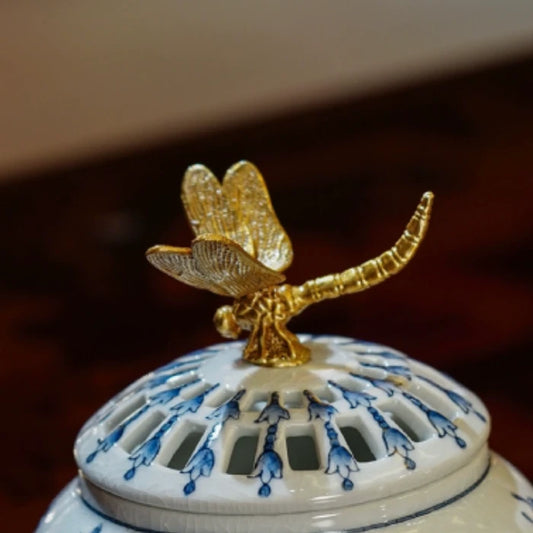 Full view of ceramic aroma stove with brass dragonfly ornament on lid