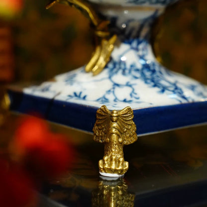 Detailed shot of brass-accented tray edge with perched blue bird decoration