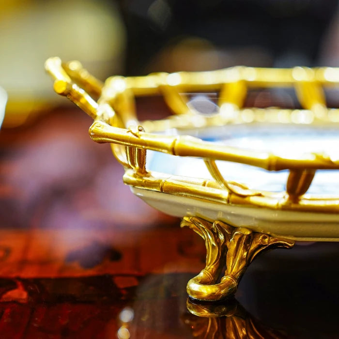 Ceramic tray used as a fruit platter with red apples and yellow pear on reflective surface
