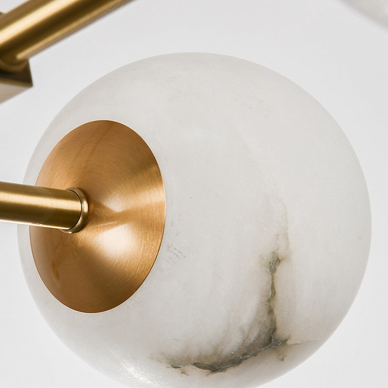 Close-up of translucent alabaster globe paired with warm brass accents