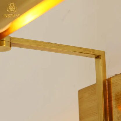 Luxury brass wall lamp with brand insignia detail