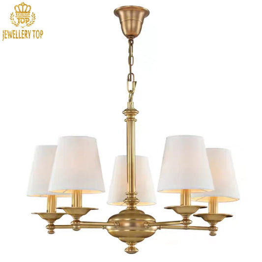 Rustic brass pendant light with tapered off-white shades and engraved details