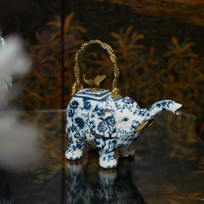Close-up of blue and white ceramic decorative ornament with brass handle and dragonfly accent