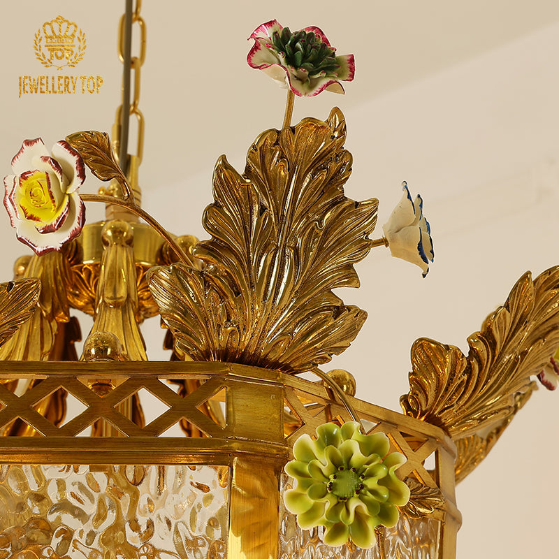 Close-up of hand-sculpted brass flowers and leaves on a vintage lamp chandelier.