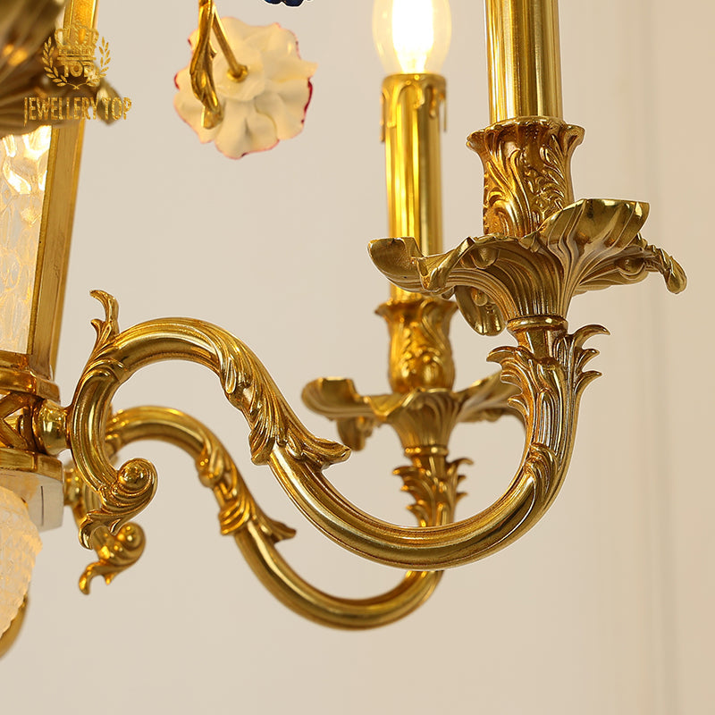 Delicate glass shades hanging from curving brass arms with botanical motifs.