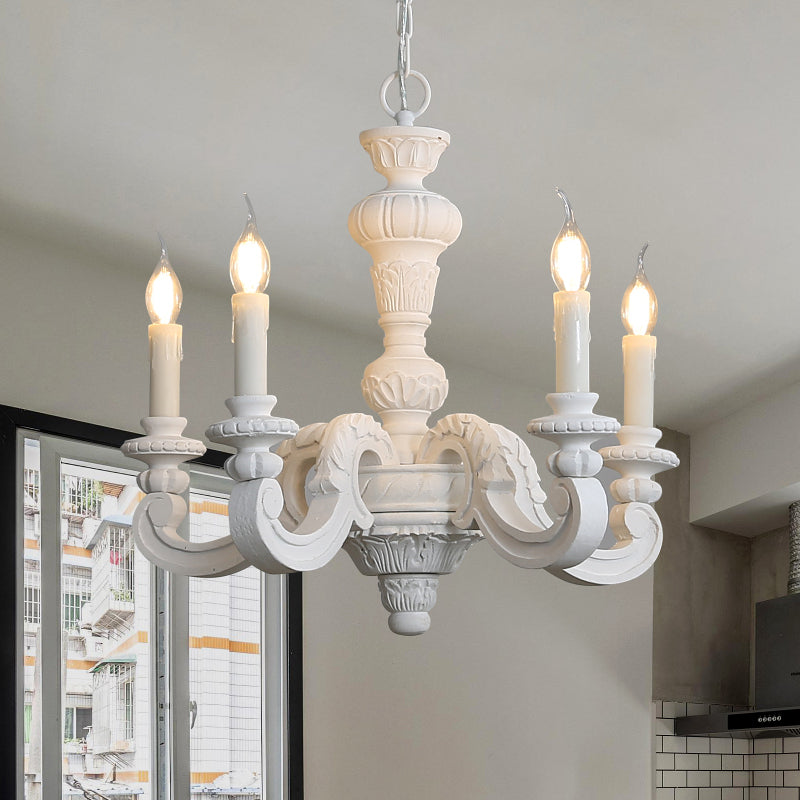 Farmhouse chandelier suspended above a rustic dining table with checkered linens