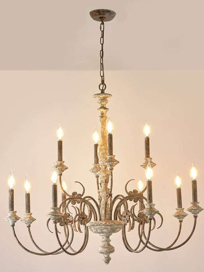 French country chandelier with scrolled iron arms and Edison bulbs in a rustic dining room