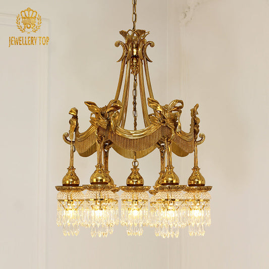 Ornate brass chandelier with draped accents, showcasing a vintage Victorian design.